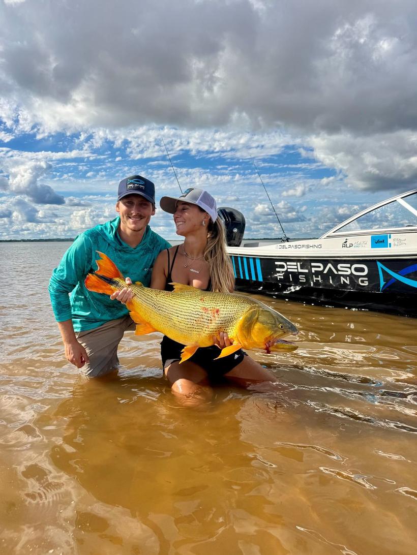 Pareja con un dorado en la orilla