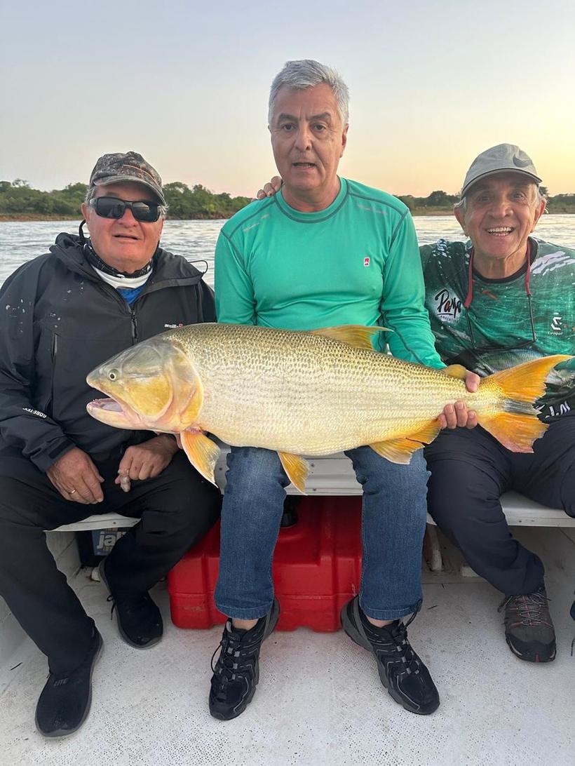 Tres pescadores con un dorado grande