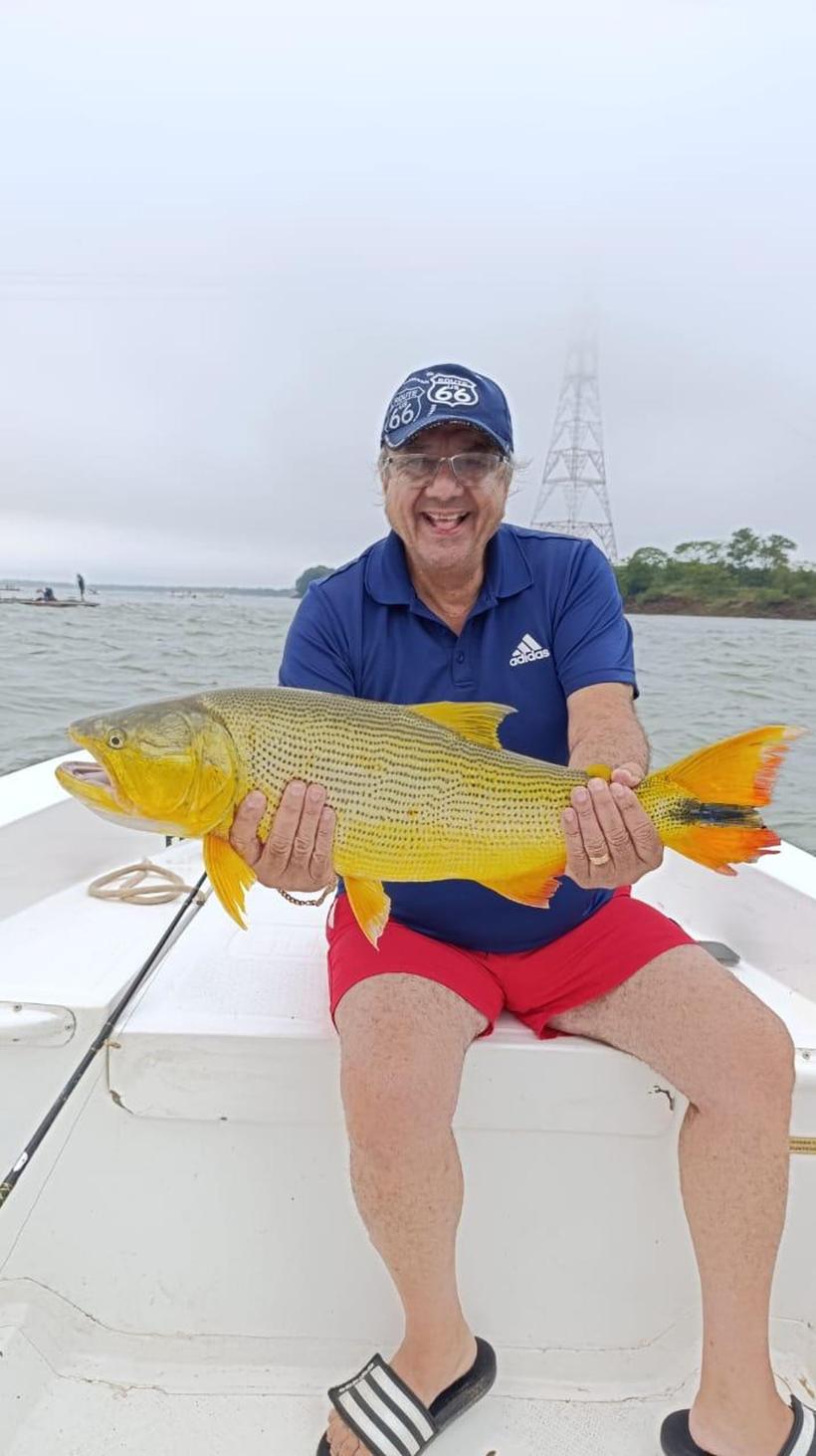 Pescador con un dorado en la lancha